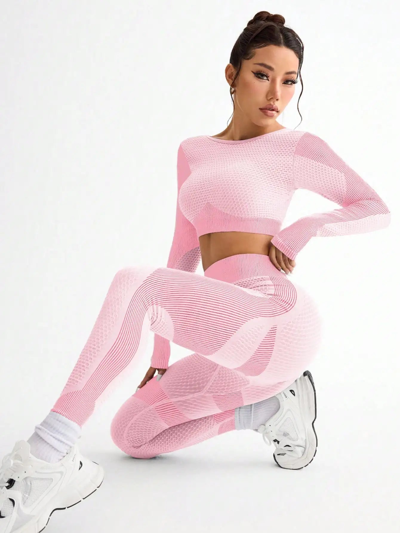 Woman wearing a pink knit outfit on a white background