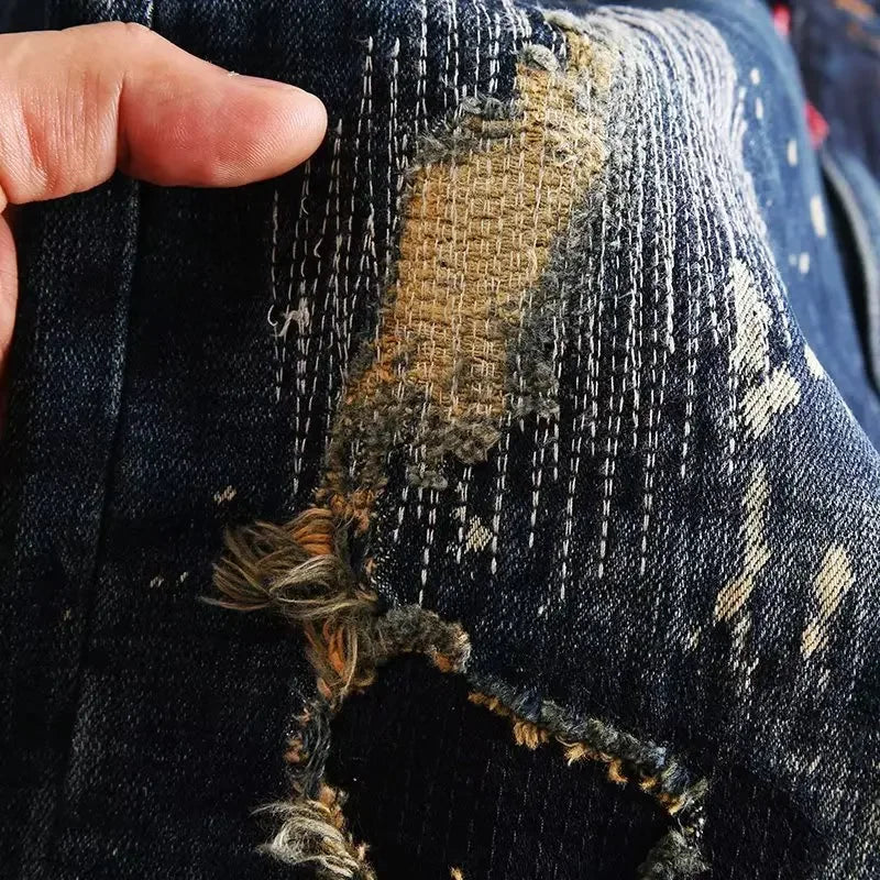 Close-up of a distressed denim fabric with a hand holding it.