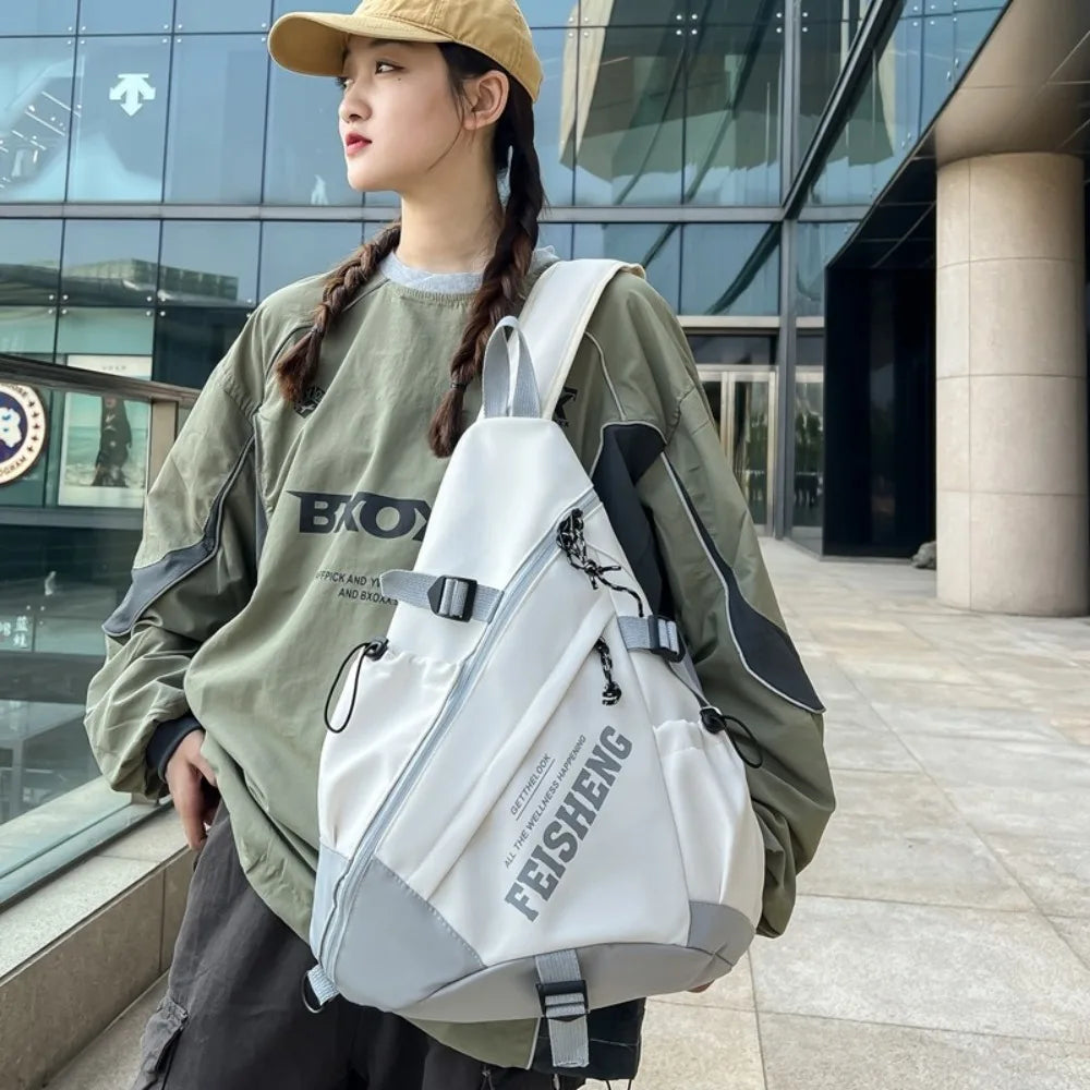 Person wearing a white backpack with visible branding, standing outdoors.