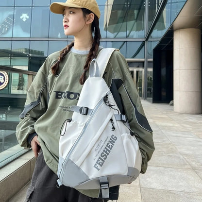 Person wearing a white backpack with visible branding, standing outdoors.
