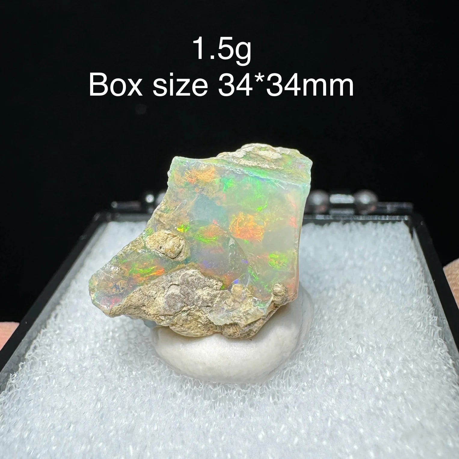 Opal stone on a white stand with text indicating weight and box size.