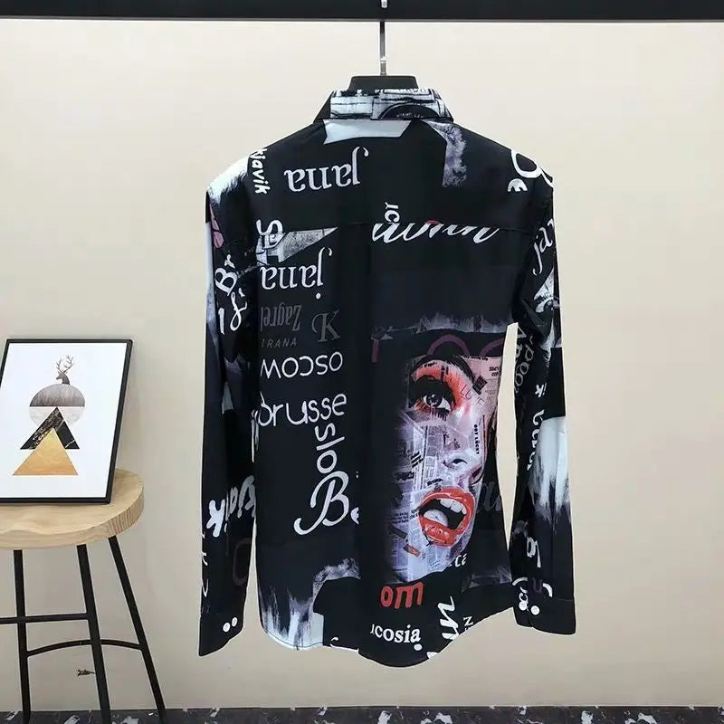 Black shirt with graphic designs and text on a hanger against a beige wall.