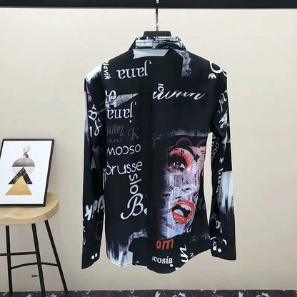 Black shirt with graphic designs and text on a hanger against a beige wall.