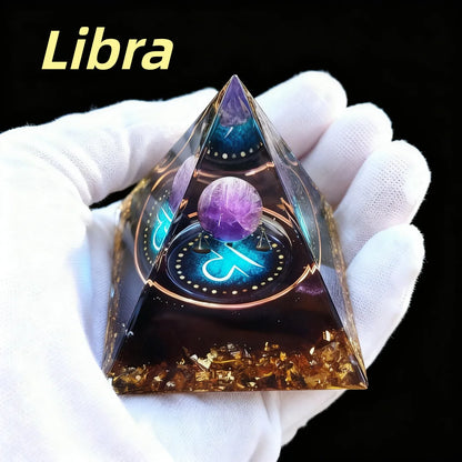 Pyramid-shaped object with a purple sphere and 'Libra' text, held by a gloved hand against a black background.