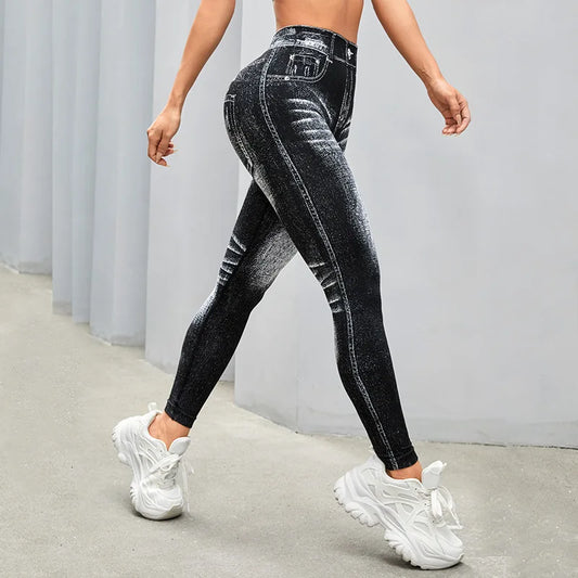 Person wearing black distressed jeans and white sneakers on a plain background