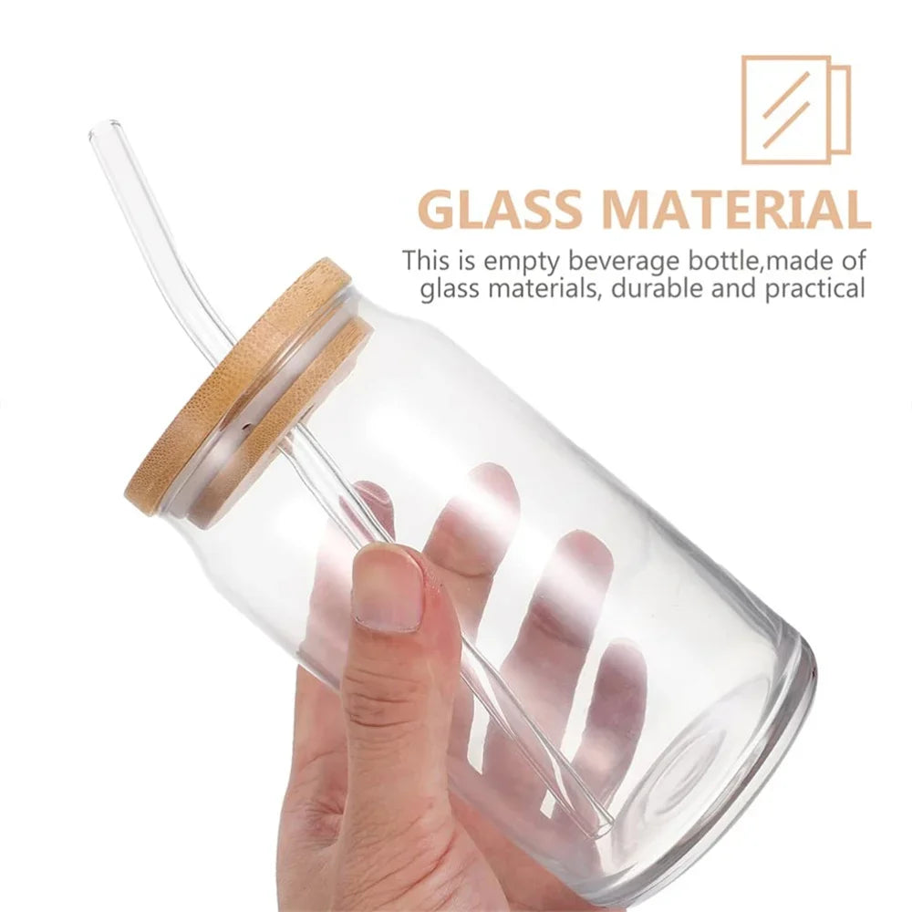 Clear glass beverage bottle with wooden cap held by a hand on a white background