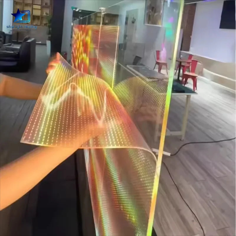 Person holding a flexible, colorful LED display in an indoor setting