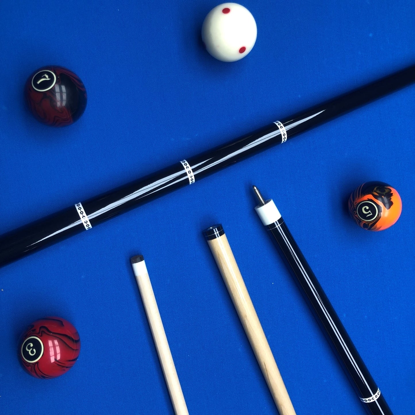 Pool cues and balls on a blue surface