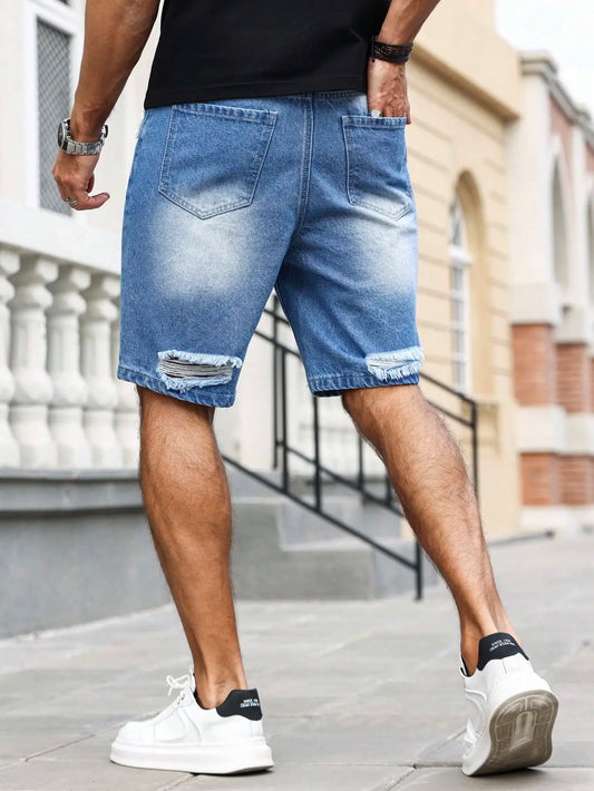 Person wearing blue denim shorts and white sneakers on a city street.