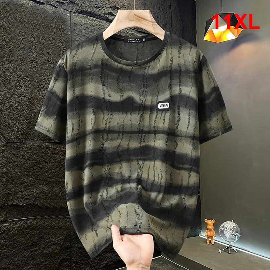 Black and gray tie-dye t-shirt on a hanger against a dark textured wall.