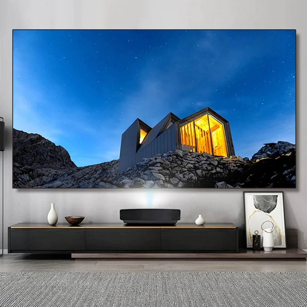 Modern living room with a large TV displaying a mountain scene, a black entertainment console, and decorative items.