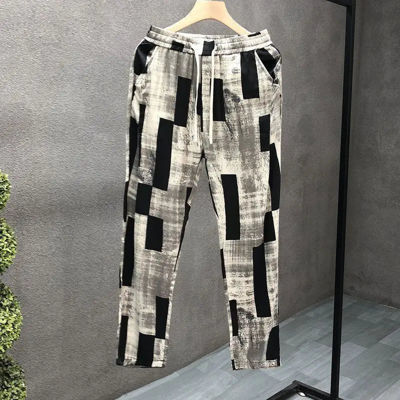 Patterned pants on a hanger against a gray background