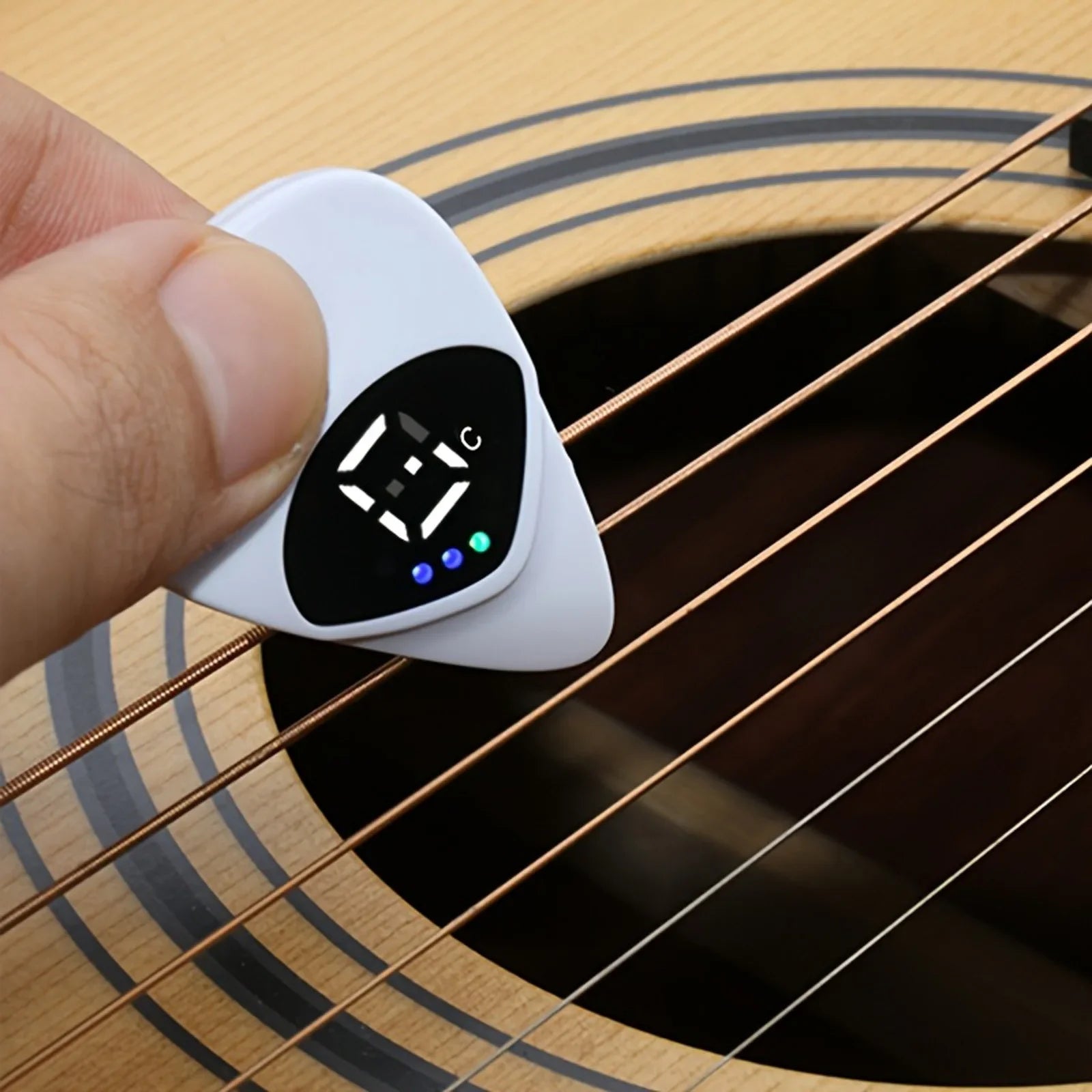 Digital guitar tuner held over a guitar string
