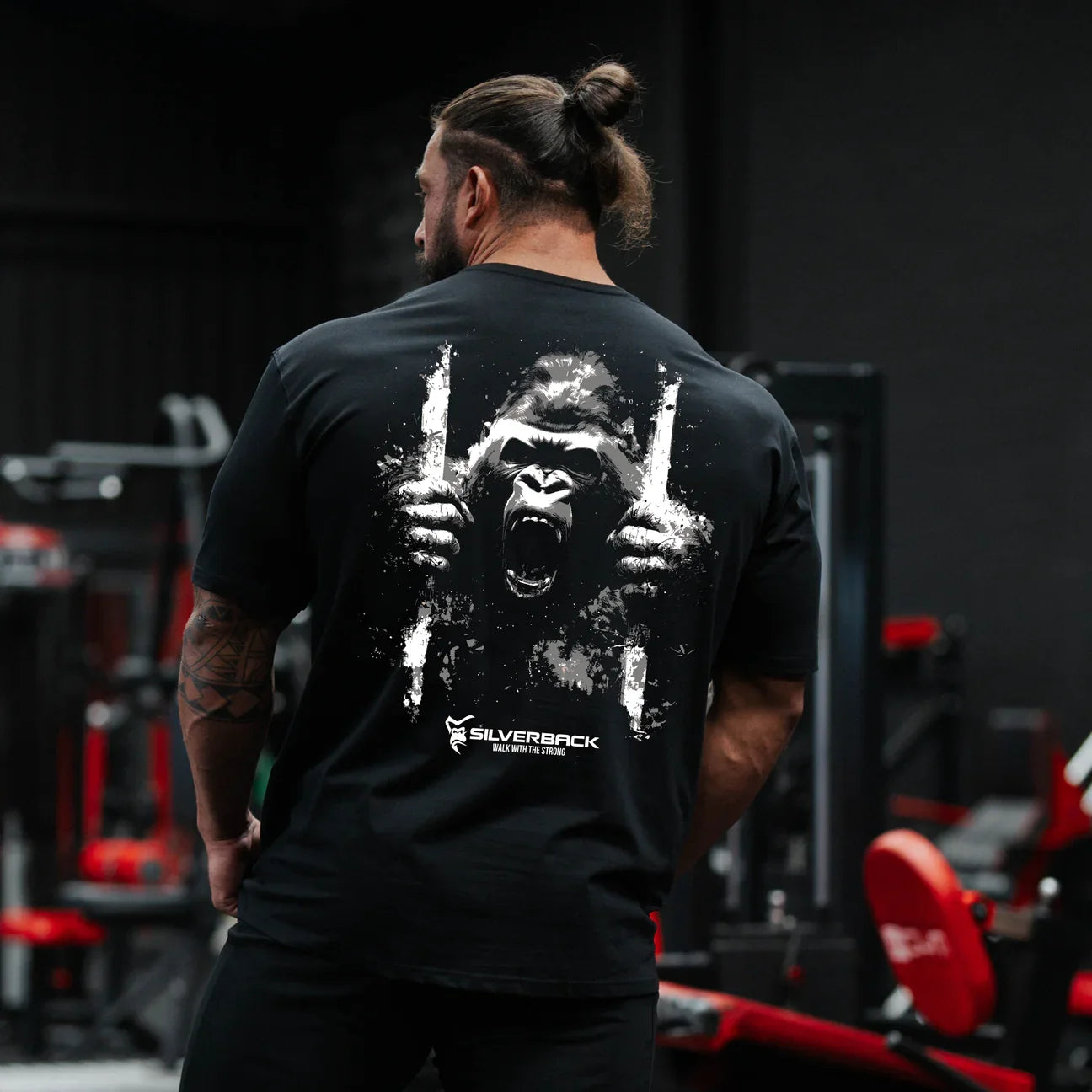Person wearing a black t-shirt with a gorilla graphic and 'Silverback' branding in a gym setting.