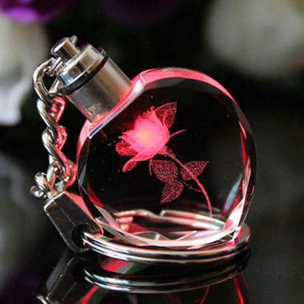 Heart-shaped crystal pendant with engraved design on a dark background