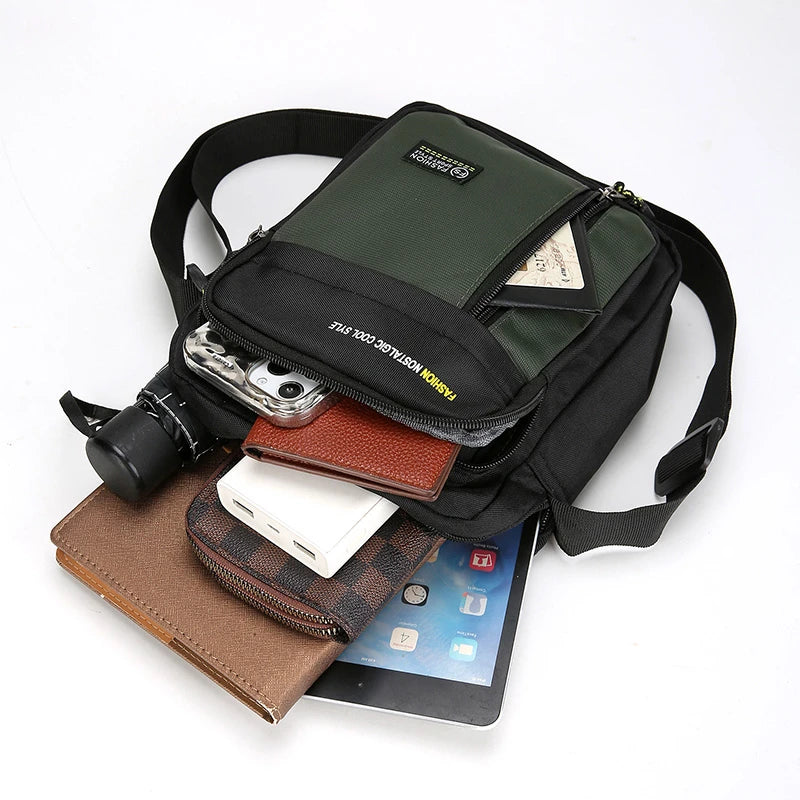 Black crossbody bag with various items including a tablet, phone, and camera on a white background