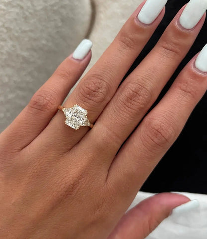 Close-up of a hand wearing a diamond ring with a blurred background