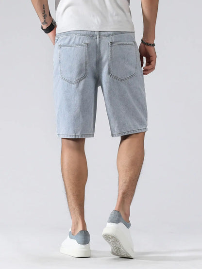 Person wearing light blue denim shorts on a white background