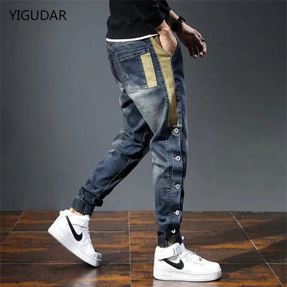 Person wearing patchwork jeans and white sneakers on a wooden floor with a gray background
