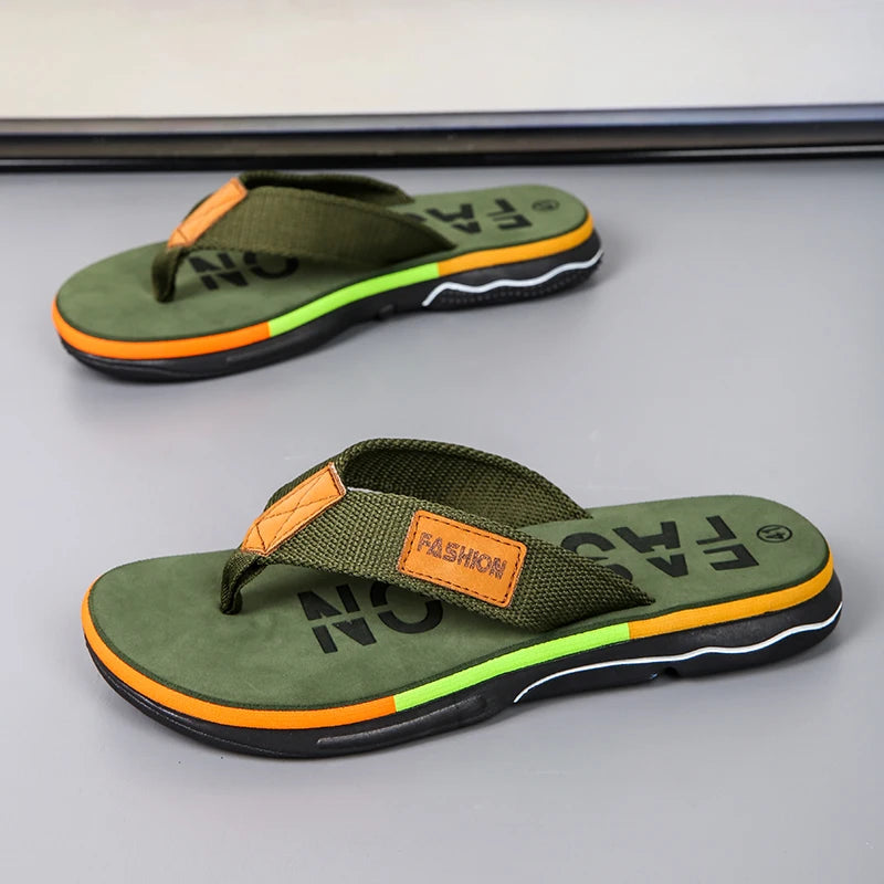 Green flip-flops with orange accents on a gray surface