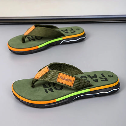 Green flip-flops with orange accents on a gray surface