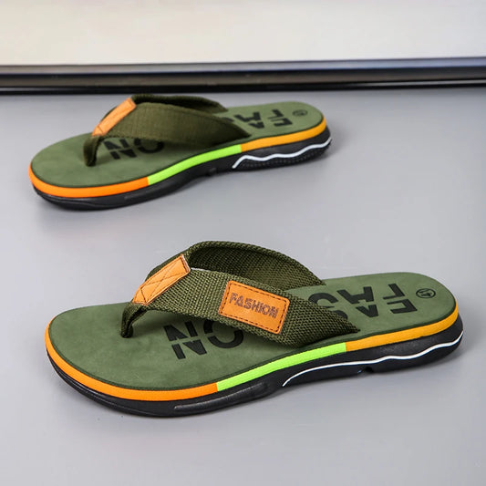 Green flip-flops with orange accents on a gray surface