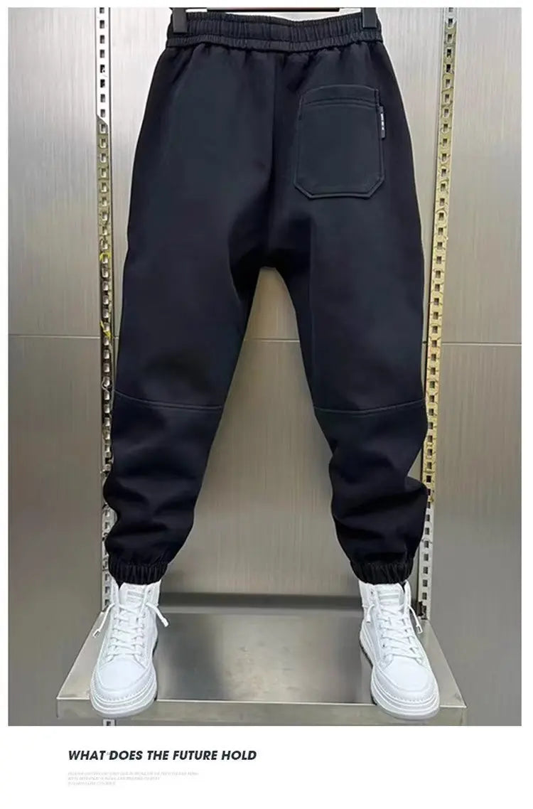 Black pants on a mannequin with white sneakers against a metallic background