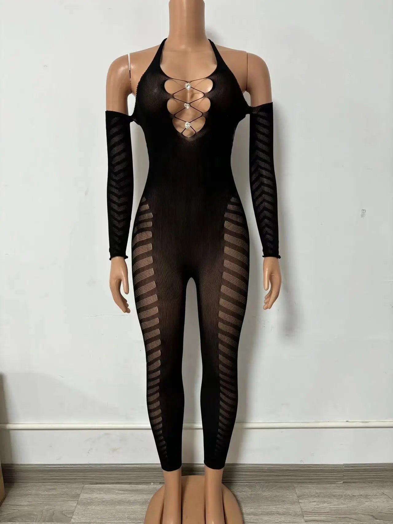 Black bodysuit with mesh panels on a mannequin against a white wall.