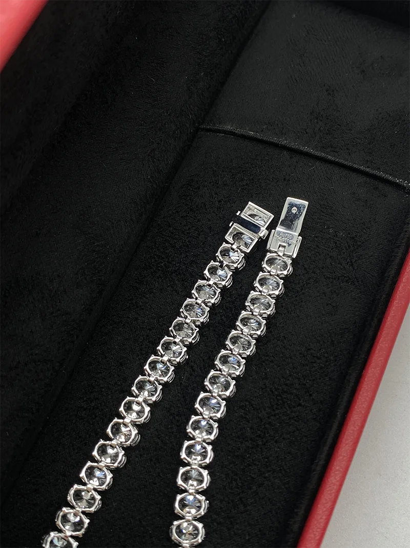 Silver bracelet with clear stones on a black surface