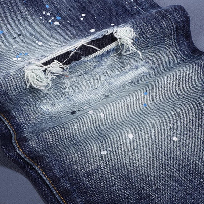 Close-up of a blue denim jeans with a ripped pocket and visible stitching.