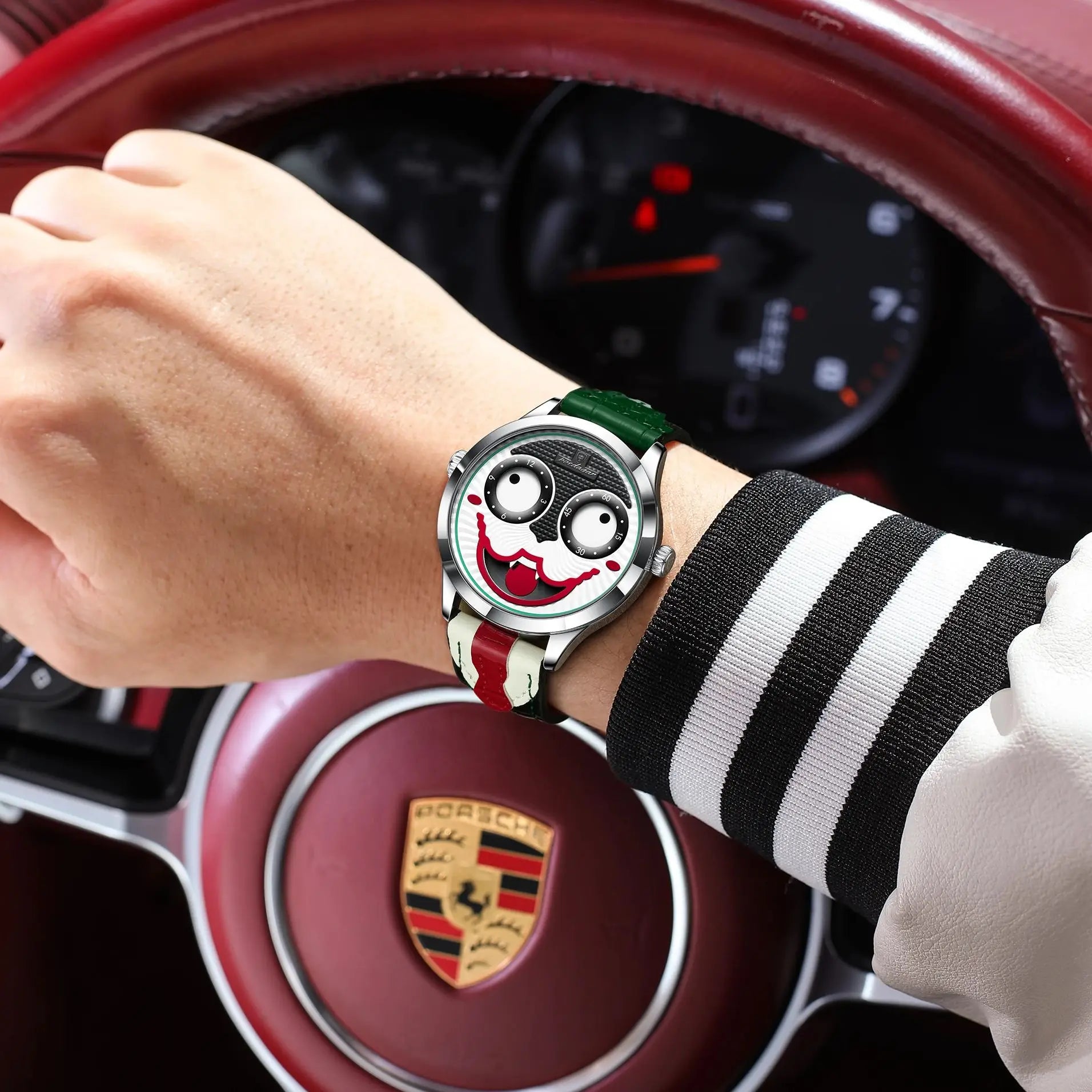 Person wearing a watch with a unique design in front of a Porsche car interior.