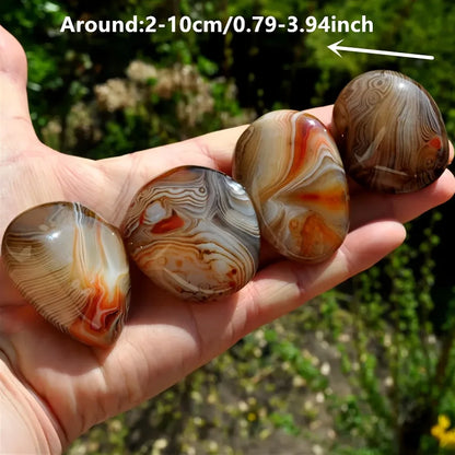 Hand holding three patterned stones with size measurement text overlay