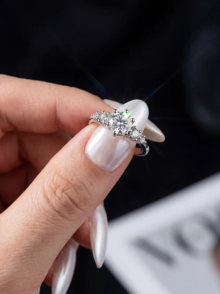 Hand holding a diamond ring with a blurred background