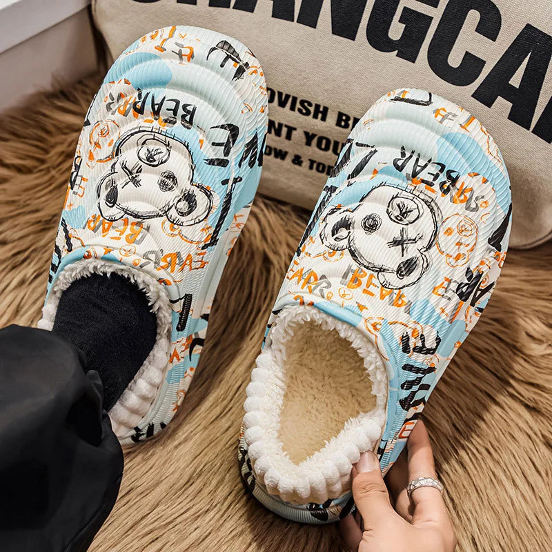 Pair of cartoon-themed slippers with paw print design on a textured surface.