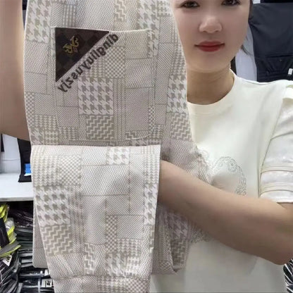 Person holding a patterned fabric with a visible brand label.