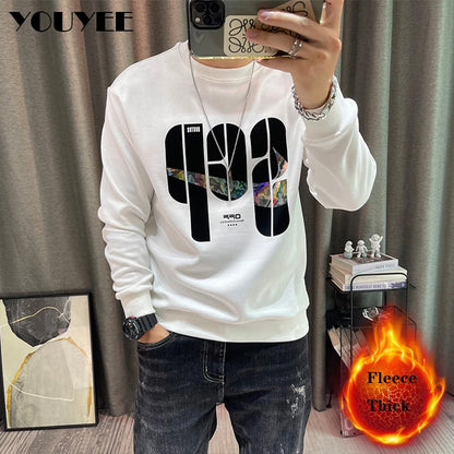 Person wearing a white hoodie with graphic design, taking a selfie in front of a curtain.