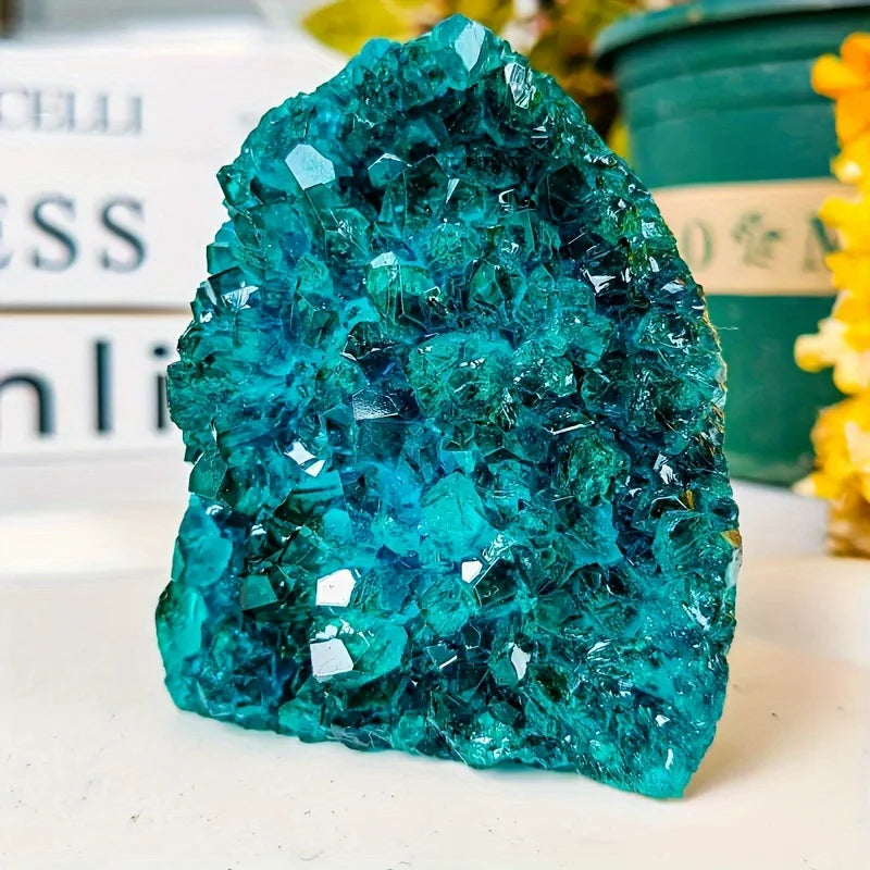 Teal crystal formation on a white surface with blurred background