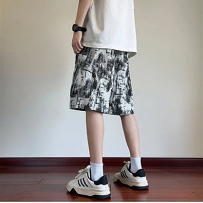 Person wearing a patterned skirt and sneakers on a plain background