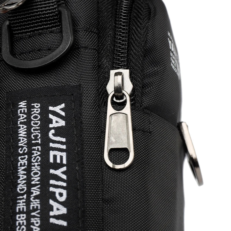 Close-up of a black bag with a zipper and visible brand name on a white background