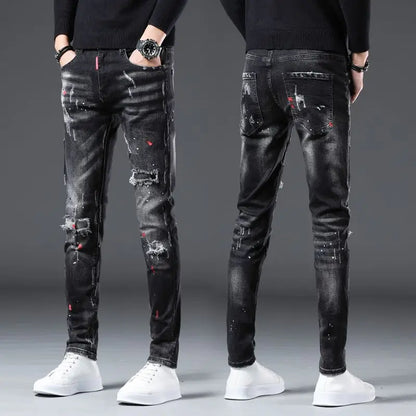 Black distressed jeans worn by a person on a gray background