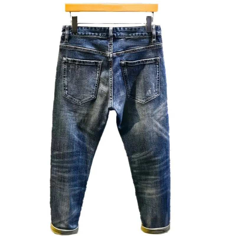 Blue jeans on a hanger against a white background