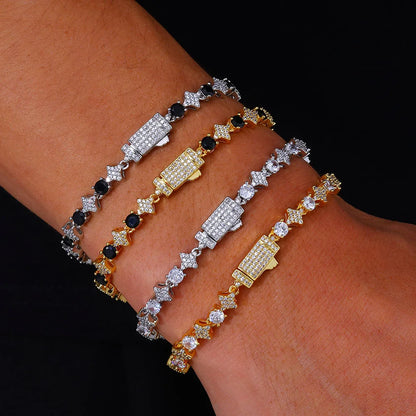 Three gold and silver bracelets with black and clear stones on a wrist against a dark background