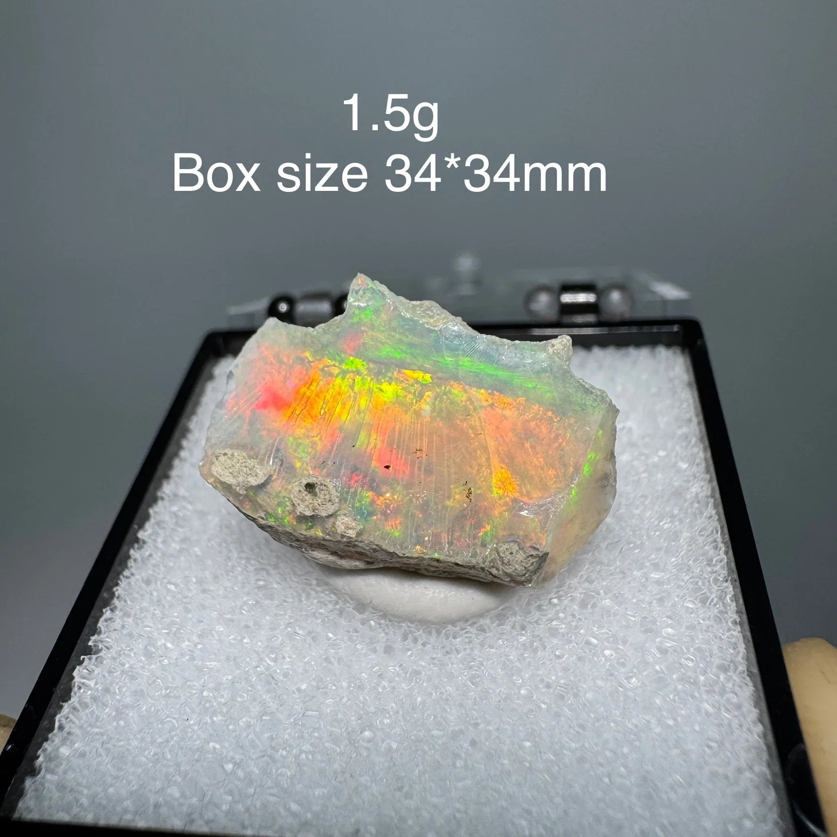 Opal stone on a black stand with size and weight information displayed.