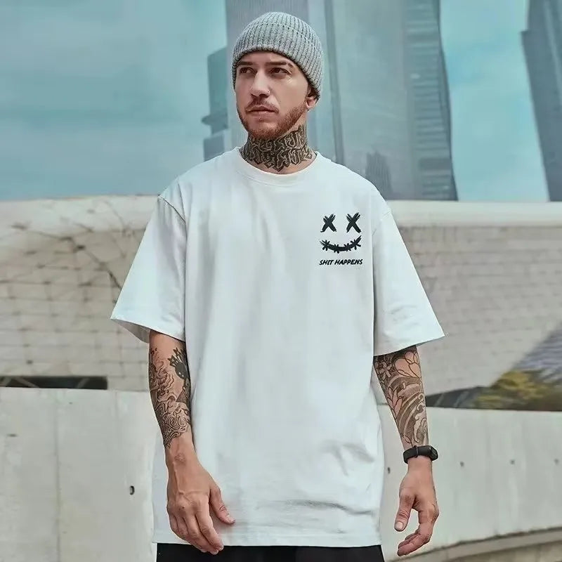 Man wearing a white t-shirt with a graphic design, standing in an urban setting.