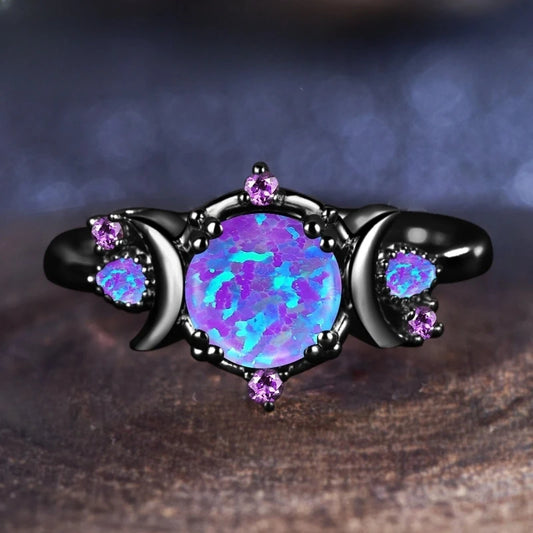 Ring with a purple opal stone and smaller gemstones on a dark background