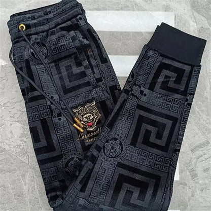 Black pants with geometric pattern and brand logo on a textured surface