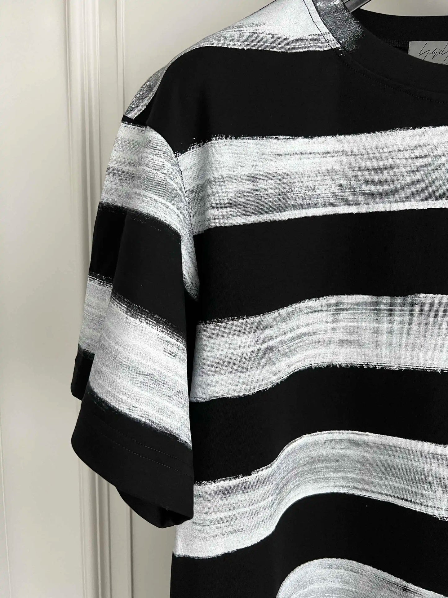 Black and white striped sweater against a plain background