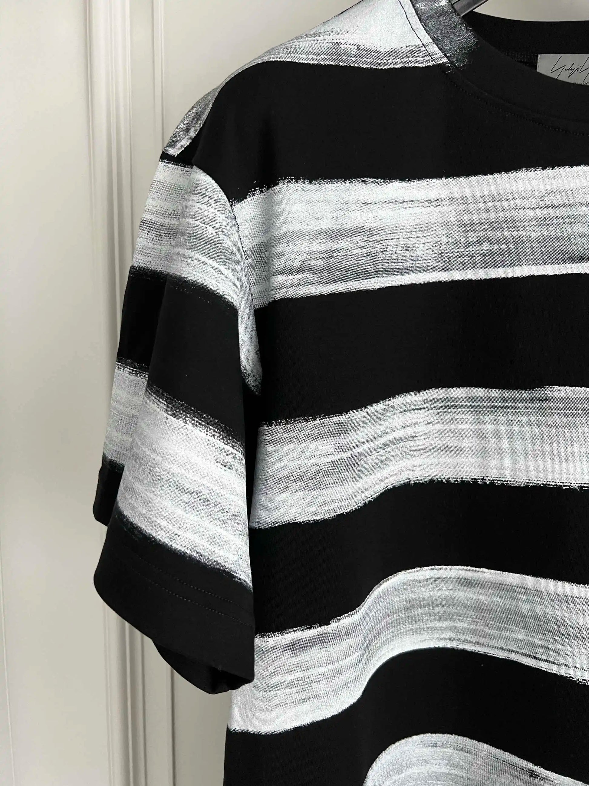Black and white striped sweater against a plain background