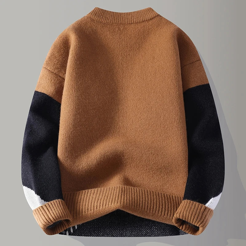 Brown sweater with black sleeves on a gray background