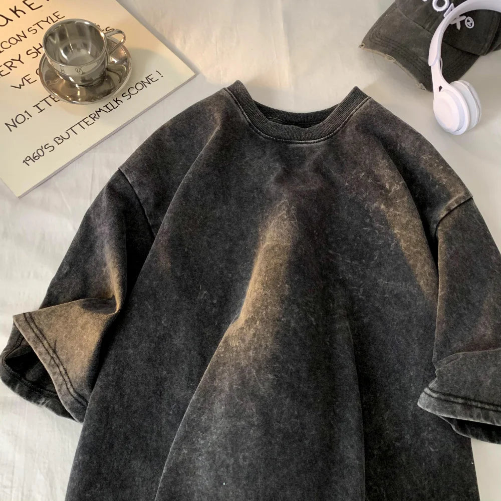 Black distressed denim jacket on a light wooden surface with a cup and text in the background.